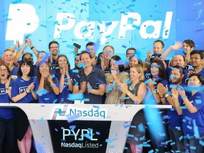 In this photo provided by Nasdaq, PayPal CEO Dan Schulman, centre, and employees ring the opening bell at the Nasdaq MarketSite in New York, Monday, July 20, 2015. (Christopher Galluzzo, Nasdaq via AP)