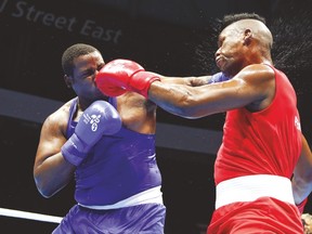 Cuba’s Lenier Pero (right) takes a punch from Bahamas’ Kieshno Majo during their Pan Am superheavyweight bout on Sunday night in Oshawa. (AP)