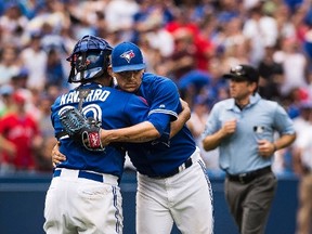 Blue Jays relief pitcher Roberto Osuna (right) gets a post-game hug from catcher Dioner Navarro after striking out three Tampa Bay Rays in the ninth inning on July 19, 2015. (AARON VINCENT ELKAIM/The Canadian Press)