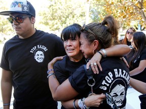 In this Sept. 5, 2014, file photo, relatives of the late Armando Villa, Joshua Castaneda, left, and his mother Martha Castaneda and Villa's aunt, Maria Castaneda, right, react, as California State University, Northridge CSUN President Dianne Harrison, reads a statement regarding Pi Kappa Phi Fraternity activities that lead to the death of CSUN student Armando Villa, at a news conference at the CSUN campus in Northridge, Calif.  (AP Photo/Damian Dovarganes, File)