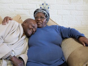 In this photo supplied by Oryx Media retired Anglican Archbishop Desmond Tutu, left, with his wife Leah, right, at the Tutu home in Cape Town South Africa Tuesday, July 21, 2015. Tutu returned home after a weeklong hospital stay and is under doctor's instructions to rest his foundation said. (Benny Gool/Oryx Media via AP)