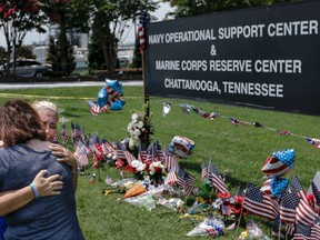 Sophia Ensley, right, and Barbie Branum embrace in front of a makeshift memorial at the Navy Operational Support Center and Marine Corps Reserve Center, Saturday, July 18, 2015, for the victims of the July 16 shootings  in Chattanooga, Tenn. (Doug Strickland/Chattanooga Times Free Press via AP)