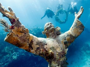 Participants in a 50th anniversary celebration for John Pennekamp Coral Reef State Park, approach the Christ of the Abyss statue with a ceremonial garland in the Florida Keys National Marine Sanctuary off Key Largo, Florida, December 10, 2010. REUTERS/Stephen Frink/Florida Keys News Bureau/Handout