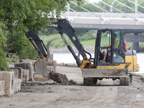 A crew cleans the Parks Canada side of riverwalk earlier this month. It opened to the public on Tuesday. (Brian Donogh/Winnipeg Sun file photo)