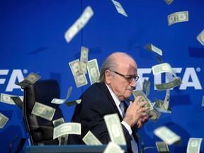 FIFA president Sepp  Blatter is photographed  while banknotes thrown by British comedian Simon Brodkin hurtle through the air during a press conference following the extraordinary FIFA Executive Committee at the  headquarters in Zurich, Switzerland, Monday, July 20, 2015.  (Ennio Leanza/AP)