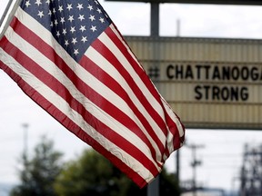 U.S. flag flies alongside a sign in honor of the four Marines killed in Chattanooga, Tennessee July 17, 2015. Four U.S. Marines were killed on Thursday by a suspected gunman the FBI has confirmed as Mohammod Youssuf Abdulazeez, who opened fire at two military offices in Chattanooga before being fatally shot by police.  At left of Killian is ATF agent Steve Gerido REUTERS/Tami Chappell