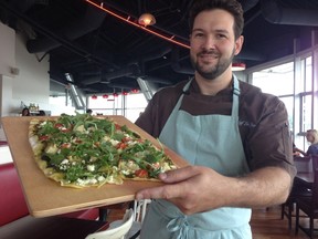 Chef Luc Jean displays one of the flatbread tarte flambee that will be on the menu at Mon Ami Louis, which opens Wednesday on the Esplanade Riel. (David Larkins/Winnipeg Sun)