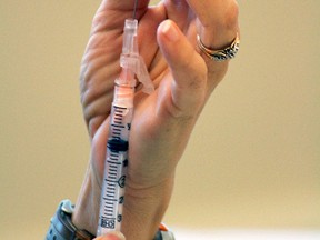 A health worker prepares an immunization needle.. (EDMONTON SUN/File)