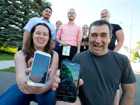 Blue team member Niki Sumpeter, and green team member Yves Dumont, are joined by fellow Ingress players Josh Shack, Sara Dresser, Matt Mitchell, Vicky Robert and Cindy Cor, near a collection of portals, as seen on their phones, near Dumont and Cor's Boullee Street home in London. (CRAIG GLOVER, The London Free Press)