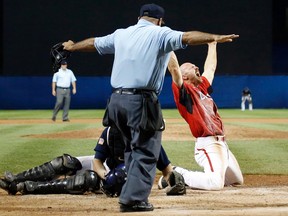 Canada's Peter Orr (right) reacts after scoring the game-winning run under the tag of United States catcher Thomas Murphy's in the 10th inning of the gold medal baseball game at the Pan Am Games in Ajax, Ontario, on July 19, 2015. Canada won the gold medal. (JULIO CORTEZ/AP)
