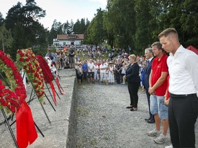 Norwegian Prime Minister Erna Solberg, leader of the Labour Party Jonas Gahr Stoere, leader of the national support group of relatives of the victims Trond Henry Blattmann and leader of Labor Youth of Norway (AUF) Eskil Pedersen attend a wreath laying ceremony on Utoya Island, on July 22, 2014, during a memorial day for the 69 people killed during Anders Behring Breivik's shooting rampage in 2011. (AFP/HEIKO JUNGE)