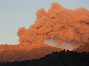 Mount Raung volcano emits huge clouds of ash and gas as seen early on July 17, 2015 from Jampit village in Bondowoso located in eastern Java island. Thousands of Indonesians were spending a miserable Eid Friday after failing to make it home to see their families after erupting volcanoes closed six airports, including in the country's second-biggest city. (AFP/WIDARSHA)