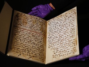 A university assistant shows fragments of an old Quran at the University in Birmingham, in Birmingham central England Wednesday, July 22, 2015. (AP/Frank Augstein)