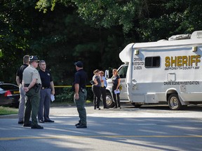 Law enforcement investigate the scene of a shooting a home in Suwanee, Ga. July 22, 2015. (AP Photo/John Amis)