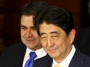 Japan's Prime Minister Shinzo Abe (R) and Honduras' President Juan Orlando Hernandez arrive for talks at Abe's official residence in Tokyo July 22, 2015. REUTERS/Thomas Peter