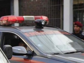 A police car is pictured outside a school targeted by extortionists at San Juan de Lurigancho district, in Lima on June 10, 2015. (AFP PHOTO/ERNESTO BENAVIDES)