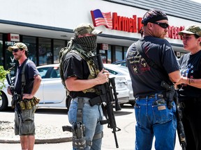 A small group of armed citizens stand guard outside a Colorado Springs, Colo.,  Armed Forces Career Center Wednesday, July 22, 2015.  Gun-toting citizens are showing up at military recruiting centres around the U.S., saying they plan to protect recruiters following last week's killing of four Marines and a sailor in Chattanooga, Tenn.  (Michael Ciaglo/The Gazette via AP)
