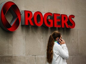 A woman speaks on her cell phone in front of a Rogers Communications Inc sign before the company's annual general meeting for shareholders in Toronto April 22, 2014. (REUTERS/Mark Blinch)