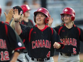 Canadian women's baseball veteran Autumn Mills (centre) is congratulated by teammates after scoring on a double by Canada's Karissa Hovinga in the sixth inning of their baseball game against Cuba at the Pan American Games in Ajax, Ont., on Tuesda,y July 20, 2015. THE CANADIAN PRESS/Fred Thornhill