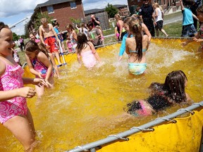 Kids taking part in camps at Loyalist College splash around in a pool set up by members of the Belleville Fire Department during the Belleville Fire Department's visit to Loyalist College, on Thursday July 23, 2015 in Belleville. 
Emily Mountney-Lessard/The Intelligencer