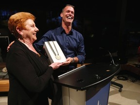 Canadian Olympian Mark Tewksbury presents his Olympic gold medal to Gail Stephens, president and CEO of Canadian Museum For Human Rights, during a press conference at the Thursday, July 23, 2015. Tewksbury, olympic gold medal swimmer, officially presented his Olympic gold medal for a new exhibit that will explore the power of sport to inspire positive change at the CMHR in Winnipeg.