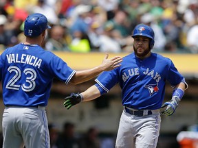 Toronto Blue Jays' Russell Martin, right, is congratulated by teammate Danny Valencia (23) after hitting a two-run home run off Oakland Athletics' Drew Pomeranz in the second inning of a baseball game Thursday, July 23, 2015, in Oakland, Calif. (AP Photo/Ben Margot)
