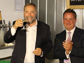 Tom Mulcair raises a glass of stout from Refined Fool Brewing Co., brewed in honour of his stop in Sarnia Thursday. The NDP leader talked up his party's plan to offer a tax credit for microbrewers. Pictured with Mulcair is Sarnia-Lambton NDP nominee Jason McMichael. (Tyler Kula/Sarnia Observer/Postmedia Network)