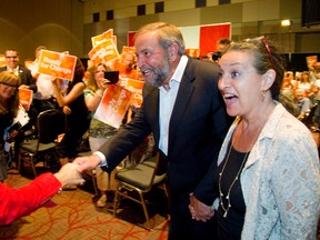 Federal NDP leader Thomas Mulcair and his wife Catherine Pinhas enter a hall at the London Convention Centre for a NDP rally Thursday. (MIKE HENSEN, The London Free Press)