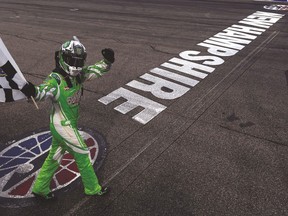 Kyle Busch celebrates with the checkered flag after winning the NASCAR Sprint Cup Series 5-Hour ENERGY 301 on Sunday. (AFP)