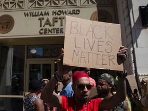 Anthony Lattimore holds a sign outside the office of Hamilton County prosecutor Joe Deters' office during a protest demanding release of video showing the shooting death of Samuel Dubose by a University of Cincinnati police officer, Thursday, July 23, 2015, in Cincinnati. Deters has said he won't release the video until the investigation into Sunday's shooting is complete. (AP Photo/John Minchillo)