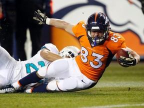 Denver Broncos wide receiver Wes Welker (83) is brought down by Miami Dolphins strong safety Jimmy Wilson after making a catch during the second half at Sports Authority Field at Mile High. (Chris Humphreys/USA TODAY Sports)