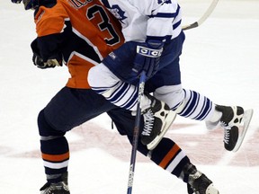 Toronto Maple Leafs winger Tom Fitzgerald rides the back of New York Islanders defenceman Adrian Aucoin as they chase the puck during NHL play in Uniondale, N.Y,, December 27, 2003. (Postmedia Network file photo)