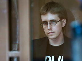 Ilya Goryachev looks from a defendants' cage in a courtroom in Moscow, Russia, Friday, July 24, 2015. (AP Photo)