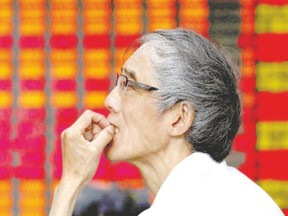 An anxious investor looks at an electronic board showing stock information at a brokerage house in Shanghai, China. Chinese stocks rose for a second day Friday, buoyed by a barrage of government support measures, but worries persist about the long-term impact that four weeks of stock market turmoil may have on the world?s second-largest economy.  (Aly Song/Reuters)