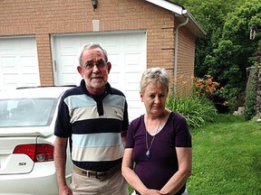 Peter and Barbara Dunnett in front of their Kingston home on Friday July 24 2015. Last winter the couple and nearly a hundred other Kingston households, the water line coming into their house froze solid – and stayed that way well into spring. Nearly five months later, the Dunnetts continue to be frozen out by Utilities Kingston which refuses to pay a plumber’s bill of $443.46, rung up in an unsuccessful attempt to thaw their line.Paul Schliesmann/The Kingston Whig-Standard/Postmedia Network