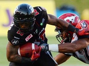 Calgary Stampeders' Deron Mayo attempts to tackle Ottawa Redblacks' Jock Sanders during second quarter CFL football action in Ottawa on Friday, July 24, 2015. 
THE CANADIAN PRESS/Sean Kilpatrick