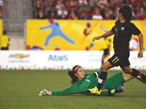 Mexico’s Monica Ocampo watches her shot sail into the net after beating Canada’s goalkeeper Stephanie Labbe during last night’s bronze-medal game. (POSTMEDIA NETWORK)