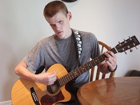 Visual impaired Jason Lamont plays the acoustic guitar at his house in Seaforth.(Shaun Gregory/Huron Expositor)