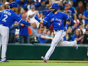 Toronto Blue Jays right fielder Jose Bautista (19) bumps fists with third base coach Luis Rivera (2) after hitting a solo home run against the Seattle Mariners during the sixth inning at Safeco Field. Mandatory Credit: Joe Nicholson-USA TODAY Sports