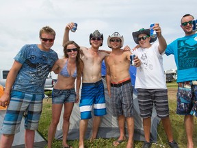 Steve Wurz (centre) from Silvan Lake, Alta., poses for a photo with his friends during Big Valley Jamboree 2014 in Camrose, Alta., on Sunday, Aug. 3, 2014. Ian Kucerak/Edmonton Sun
