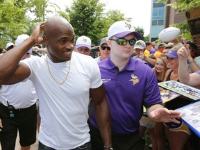 Minnesota Vikings running back Adrian Peterson smiles at fans as he reports to training camp at Minnesota State University Saturday, July 25, 2015, in Mankato, Minn. (AP Photo/Charles Rex Arbogast)