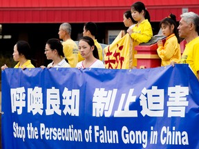 Falun Gong members protest the group's persecution in China, at 97 street and 107 Avenue, in Edmonton Alta. on Saturday July 25, 2015. David Bloom/Edmonton Sun/Postmedia Network