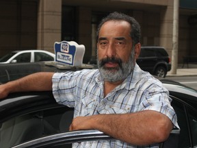 Nasser Lavasany, who owns a single Ottawa taxi licence, says it's increasingly tough for cabbies to hack out a living because of competition from Uber and a downturn in the economy. He's shown outside his cab on Albert St., in downtown Ottawa, Saturday, July 25, 2015. 
(Corey Larocque, Ottawa Sun)