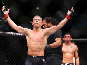 TJ Dillashaw, front, celebrates after defeating Renan Barao, rear, as referee Herb Dean, center pulls him away during their bantamweight mixed martial arts title bout during UFC Chicago on Saturday, July 25, 2015, in Chicago. (AP Photo/Jeff Haynes)