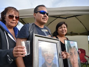 Murder victim Colton Crowshoe's father Jimmy (centre) stands with aunts Donna Manyfingers (left) and Danielle Crowshoe (right) during a candlelight vigil held on Saturday July 25, 2015 in a park in Abbeydale. Colton went missing and was found murdered in July, 2014. Bryan Passifiume/Calgary Sun/Postmedia Network