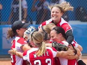 Teammates mob Canada’s pitcher Sara Groenewegen after recording the final out to beat the U.S. in extra innings and secure gold in women’s softball at the Pan Am Games in Ajax on Sunday. (THE CANADIAN PRESS/PHOTO)