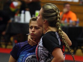 Fiona McQuade (blue shorts) from Team Renzio Gracie Sudbury MMA grapples with teammate Noemie Lavigne after jumping guard during the 2015 Budo Open Brazilian jiu-jitsu tournament at Cambrian College on Saturday. Ben Leeson/The Sudbury Star/Postmedia Network