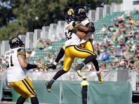 Hamilton Tiger-Cats Jasper Collins Jr., right, celebrates his touchdown with teammate C.J. Gable, centre, while playing against the Saskatchewan Roughriders during the second half of their CFL football game in Regina, Saskatchewan July 26, 2015. The Tiger-Cats won the game 31-21. (REUTERS/David Stobbe)
