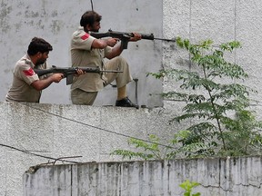 Indian policemen take their positions next to a police station during a gunfight at Dinanagar town in Gurdaspur district of Punjab, India, on July 27, 2015. (REUTERS/Munish Sharma)