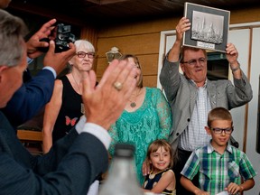 Leon Benoit stands with his family while holding up a plaque he was given by the Conservative Association for the riding of Lakeland on Thursday, July 21 at the Mannville Riverview Golf Course. - James Wood/Postmedia Network